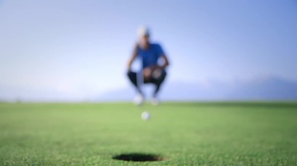 Golfer analyzing the trajectory and put. Pro golfer on a beautiful green, perfect light - Powered by Adobe