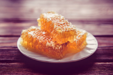 honey in honeycombs on a white plate 
