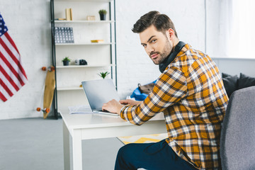 Freelancer working by laptop at home office