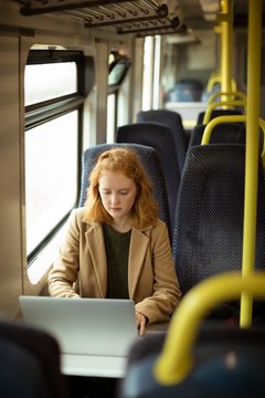 Red hair young woman using her laptop
