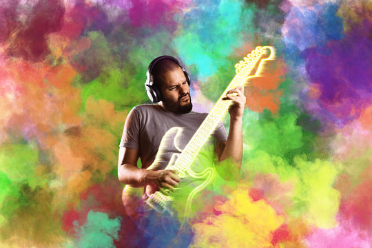 Man with headphones plays virtual electric guitar in holi color cloud © TeamDF
