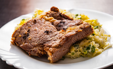 meat fillet with vegetables salad in a plate on wooden table