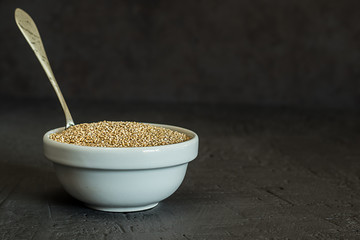 Quinoa seeds in a bowl and spoon