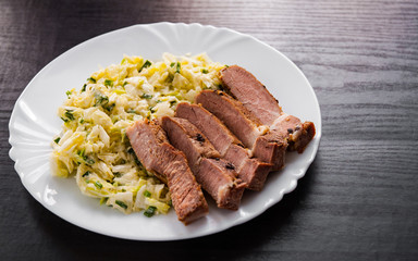 meat fillet with vegetables salad in a plate on wooden table