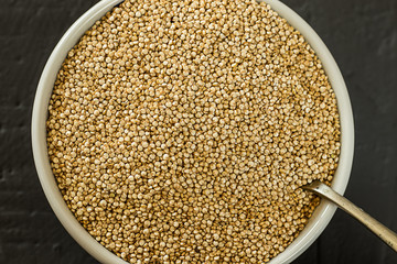 Quinoa seeds in a bowl and spoon