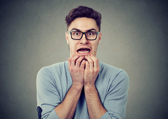 Scared anxious man on gray backdrop