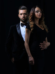 elegant man and woman posing next to each other on studio.
