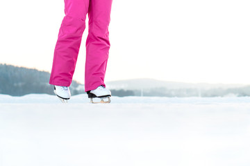 Woman ice skating on an outdoor track. Skater exercising and training in winter. Figure skating on a lake or pond. Negative copy space.