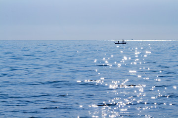 silhouette of fisherman boat in calm sea with beautiful reflection on water