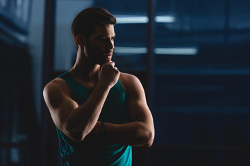 Fototapeta na wymiar silhouette of thoughtful muscular sportsman in gym