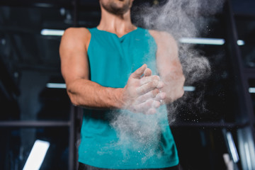 cropped view of sportsman with talcum powder in sports hall