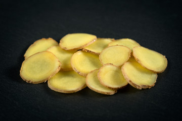 sliced ginger on a stone background