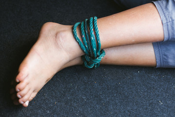 little girl with rope tied legs in car,Criminal stealing child in human child traficking concept,children thief,Dangerous in the city.