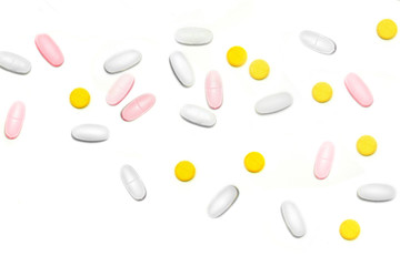 a lot of multicolored pills and tablets on the white background with copy space for text. Close up