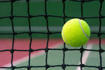 Tennis ball hitting to net on blur tennis court background