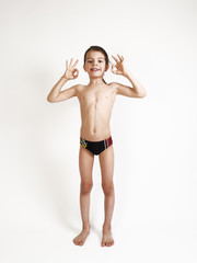 Fototapeta premium smiling elementary 7 year olds boy thumbs up over white