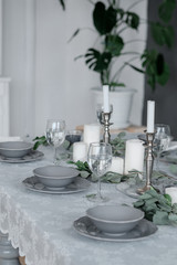 Wedding or festive table setting. Plates, wine glasses, candles and cutlery