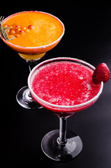 two classic and strawberry margarita, white and red alcoholic cocktail with decoration of salt on the edge of the glass with fresh lime, lemon, daiquiri on gray background restaurant. Bar alcohol menu