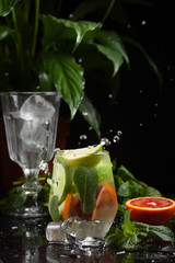 lemonade in a glass on a dark background. spray and motion