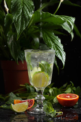 lemonade in a glass on a dark background. spray and motion