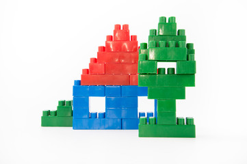 Naklejka premium house with windows and a roof of a designer colored cubes on a white background, a green tree built of cubes
