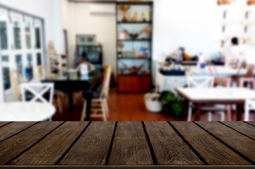 Selected focus empty brown wooden table and Coffee shop or restaurant blur background with bokeh image. for your photomontage or product display.