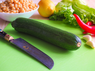 Vintage Arabic knife and zucchini. Cooking vegetable salad with chickpeas.

