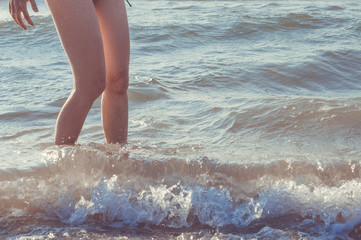 Close up of woman legs in sea in summer holidays. Vacation concept.