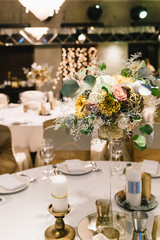 Candle and flower decoration for an event party or wedding on the table in restaurant.