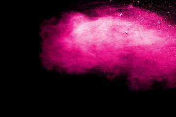 abstract pink dust explosion on  black background.abstract pink powder splattered on black...