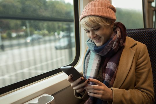 Woman using mobile phone while travelling in bus