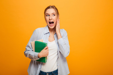 Screaming young woman student holding books.