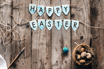 Blue chicken easter eggs and the same text "Happy Easter" on rustic wooden background with copy space. top view