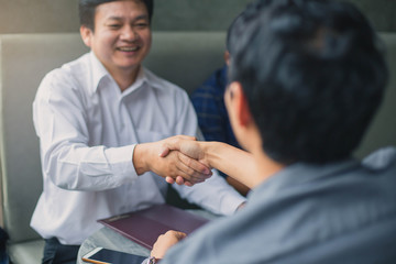 Business Team Meeting Handshake Applaud Concept. Business partners handshaking over business objects on workplace.
