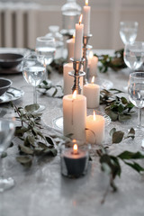 Wedding or festive table setting. Plates, wine glasses, candles and cutlery
