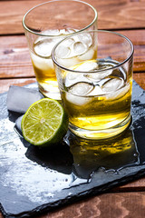 glass of whiskey on wooden background