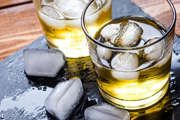 glass of whiskey on wooden background