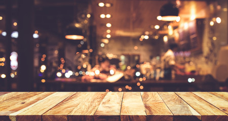 Wood table top (Bar) with blur night cafe background - obrazy, fototapety, plakaty