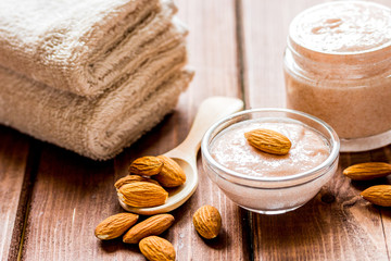 Fototapeta na wymiar spa concept with almond nuts and scrub on wooden background