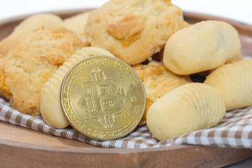 bitcoin and pile of cookies on wooden plate