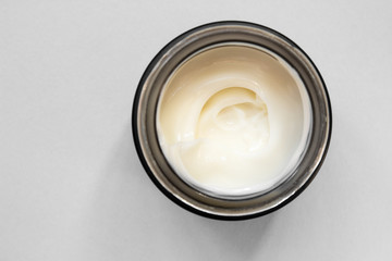 Smear cream with snail mucin in black container. Lotion for face or body. Skin care. Close up