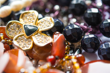 Blurred abstract art closeup with selective focus of beautiful attractive shiny beads in a fashion and handicraft accessory concept. Different elegant handmade jewellery gem necklace background