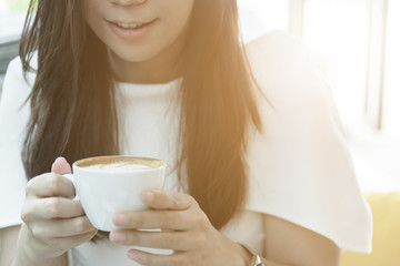 A coffee cup and beautiful asian businesswoman in the morning with working and relaxing time.