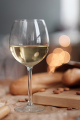 A glass of white wine and cheese on a blackboard