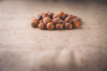 Nuts and hazelnuts in a pile on a brown fabric for proper nutrition and healthy lifestyle