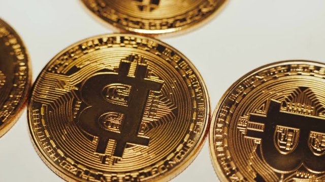 Cryptocurrency, golden bitcoins rotating on the white background. 4K