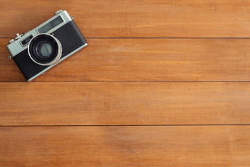 Minimal work space - Creative flat lay photo of workspace desk. Office desk wooden table with old camera. Top view with copy space. Top view of old camera over wooden table. Retro vintage filter.