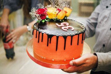 a man holds a cake of thirty-five years in his hands