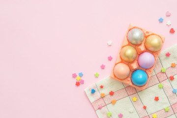 Flat lay top view colorful easter egg painted in pastel colors composition on pink pastel color background. Easter day background top view with copy space.