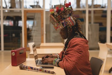 Maasai man in traditional clothing using laptop